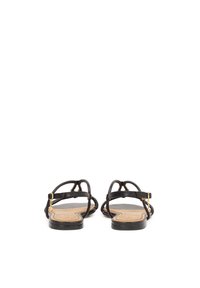 Sandali neri piatti con cinturini sottili, dettagli in metallo dorato e una suola liscia color tan, caratterizzati da un design semplice ma elegante.