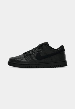 Crne Nike tenisice s reljefnim, uzorkom inspiriranim reptilima, podstavljenim okvirom i gumenim potplatom s okruglim uzorcima.
