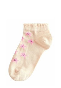 Ljusbeige ankelsocka med rosa stjärnmönster, ribbad mudd och slät yta. Har en stängd tå och en subtil randdesign.