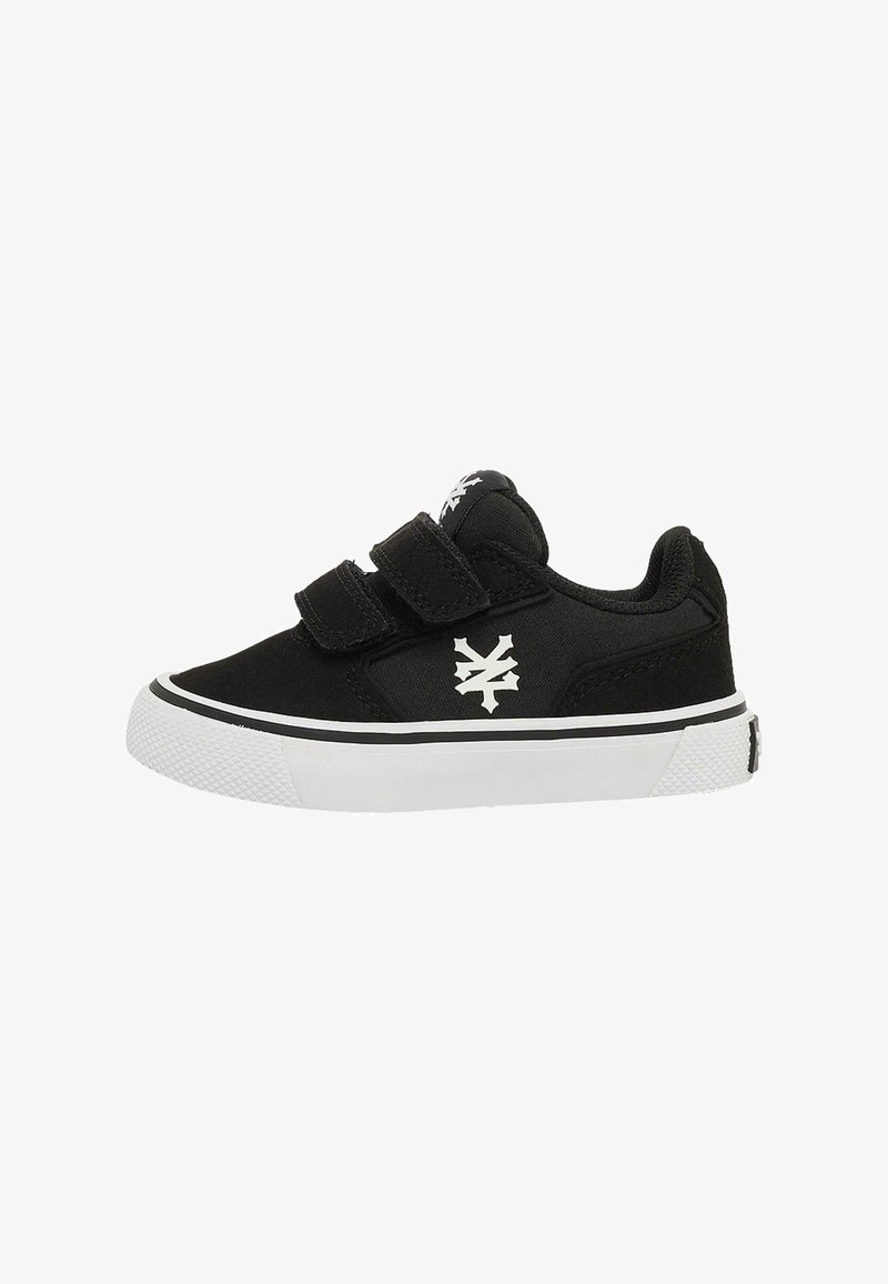 Black low-top sneaker with white sole, two Velcro straps, and a white logo on the side and tongue, shown in side profile.