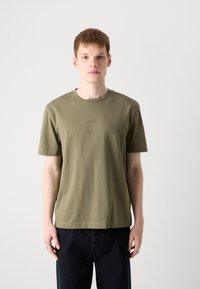 Oliven grønn bomulls T-skjorte med rund hals og korte ermer, med en liten brodert logo på brystet og rett kant.