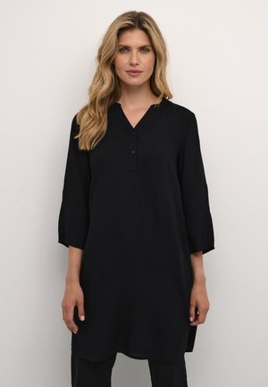 Black tunic with a V-neck and three-quarter sleeves, featuring a button placket and a relaxed fit. Lightweight fabric with a smooth texture.