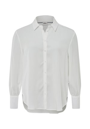 Chemise blanche à manches longues en tissu lisse. Dotée d'un col, d'une fermeture à boutons à l'avant et de manches à poignets. Fentes sur les côtés au niveau de l'ourlet.