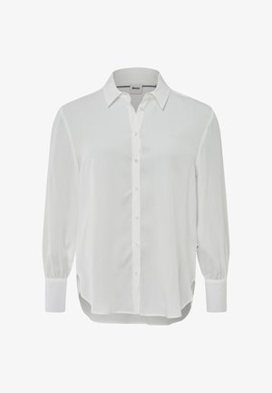 Wit overhemd met lange mouwen, gemaakt van gladde stof. Heeft een kraag, knopen aan de voorkant en manchet mouwen. Zijsplitten aan de onderkant.