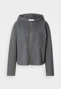 Šedá zapínacia mikina vyrobená z mäkkého materiálu, s prednou vreckom, kapucňou na šnúrku a voľným strihom s dlhými rukávmi.