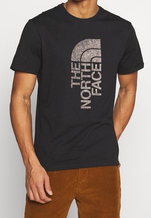 Czarny bawełniany t-shirt z pionowym, srebrnym nadrukiem logo „The North Face”. Krótkie rękawy i okrągły dekolt.