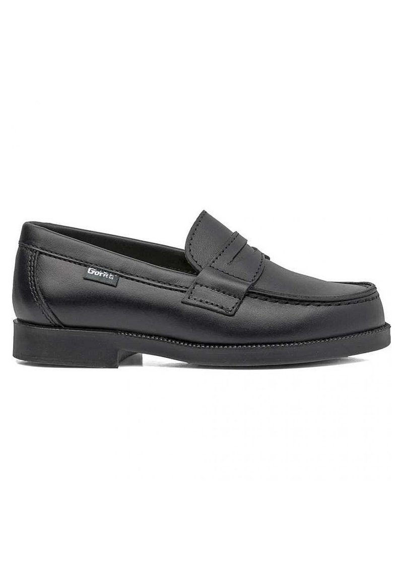 Mocasines de cuero negro con suela plana de goma, que presentan un diseño cosido y una tiras decorativa de tipo penny en la parte superior.