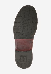 Semelle de chaussure en cuir avec un caoutchouc noir texturé et un talon en cuir marron. Présente un branding gravé et des détails de taille sur la section du talon.