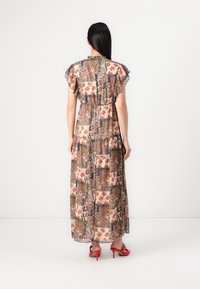 Maksikleita no viegla auduma ar ziedu apdruku, ar frill piedurknēm, elastīgu jostu un plūstošu siluetu. Redzas sarkanas kurpes ar augstiem papēžiem.