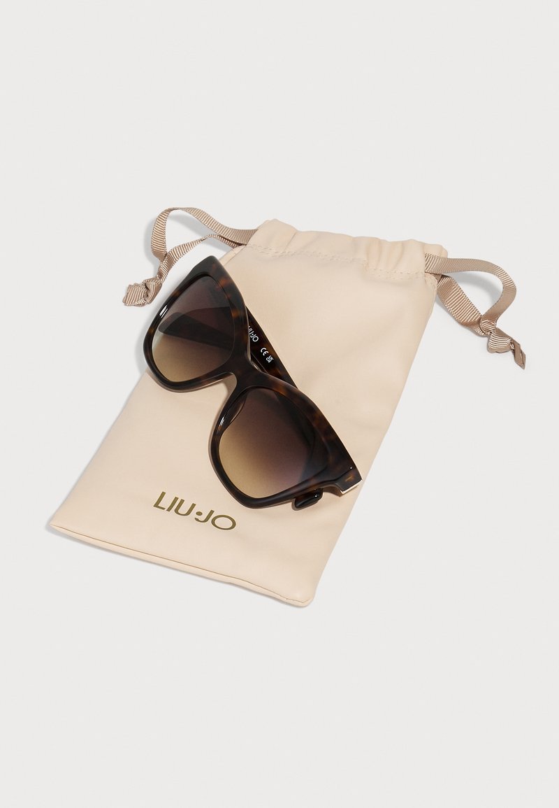 Schildpatt-Sonnenbrille mit Verlaufsgläsern, die auf einem beigen Zugbeutel liegt, der das Logo "LIU JO" in Gold zeigt.