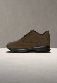Καφέ δερμάτινο παπούτσι αθλητικού τύπου με λείο φινίρισμα, στρογγυλεμένη μύτη, μαλακή σόλα και αντίθετα κορδόνια. Διακριτική λεπτομέρεια με λογότυπο στο πλάι.