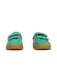 Zapatillas con velcro con parte superior de ante color verde azulado, detalles en rosa y suela de goma marrón. Cuenta con cuello acolchado para mayor comodidad y estabilidad.
