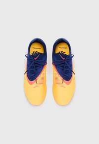 Nike Phantoms in vibrant yellow and navy blue with a textured upper, featuring orange accents and black laces. Includes logo and pattern details.