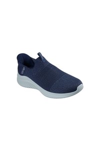 Zapato de slip-on azul marino con parte superior de punto texturizado y suela de goma. Presenta un diseño ligero y una tira en la parte trasera para facilitar su puesta.