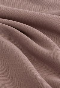 Miękka, prążkowana tkanina w przygaszonym kolorze mauve, charakteryzująca się gładką fakturą i delikatnym opadaniem, idealna do różnych zastosowań odzieżowych.