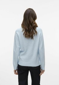 Helebe sinine kootud kampsun, mis on valmistatud pehmest materjalist, pikkade varrukatega ja lõdva lõikega, ribatud ääre ja mansettidega, vaadatuna tagant.