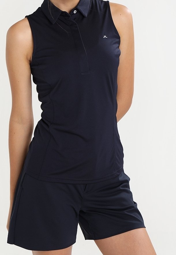 Marinblå ärmlös polo med krage och knappslå, i kombination med matchande shorts. Tillverkad av mjukt, lätt material.