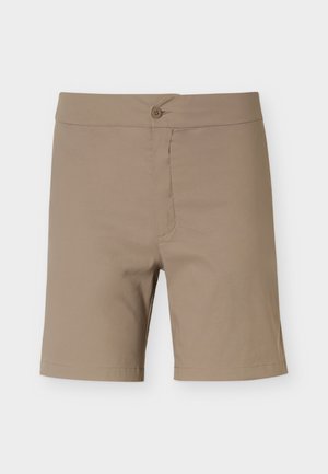 Bež kratke hlače do kolen z gumbom in nežnim šivom, prikazane ležeče na belem ozadju.