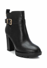 Botín negro de tobillo hecho de suave cuero sintético con un grueso tacón cuadrado, detalle de hebilla en la correa y una suela de plataforma texturizada.