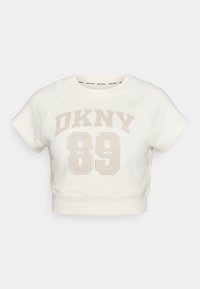 Īss krema tonis džemperis ar raglanu piedurknēm, ar gaiši beige "DKNY 89" grafiku un apaļu kakla izgriezumu. Mīksta auduma, ar ribotu apakšmalu.