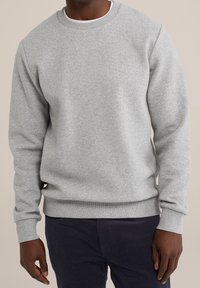 Šedá mikina s kulatým výstřihem vyrobená z texturované látky, s žebrovanými manžetami a lemem, uvolněného střihu a minimalistickým designem.