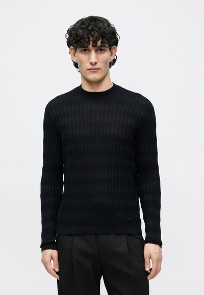 Μαύρο πουλόβερ πλεκτό με διακοσμητικό μοτίβο διαμαντιού, στρογγυλή λαιμόκοψη και μακριά μανίκια. Το ύφασμα έχει υφή και είναι εφαρμοστό στη μέση.