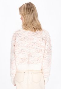 Strickpullover in Weiß mit sanften Pfirsichstreifen, lockerer Schnitt, strukturiertem Muster und geripptem Saum. Die Rückansicht zeigt die Ärmel bis zum Handgelenk.