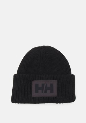 Zwarte beanie muts gemaakt van ribgebreid materiaal met een omgeslagen rand. Beschikt over een rechthoekige logopatch met een zwart ontwerp op een gestructureerde achtergrond.