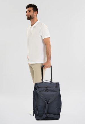 Borsa da viaggio a rotelle navy con doppie cerniere, spallacci regolabili e una robusta maniglia. Tessuto testurizzato con tasche laterali per riporre.