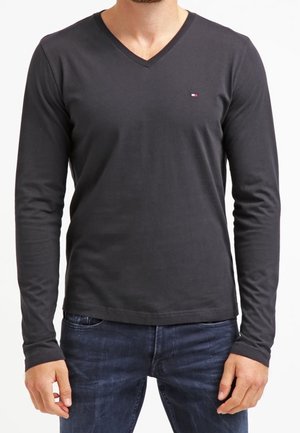 Langærmet, sort bomuldstrøje med V-udskæring, der har en lille farvet logo på brystet og en tætsiddende pasform.