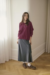 Bordo pikkade varrukatega polo, hall nahkne midi-seelik, pruunid paksude tallaga kingad, koos valgete pahkluusokkidega; pehmed, tekstuuriga materjalid.