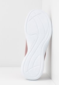 Sole boty Skechers je vyrobena z bílé gumy se strukturovaným vzorem. Svršek je z měkkého růžového síťovaného materiálu s ventilačními otvory a zakřiveným designem pro flexibilitu.