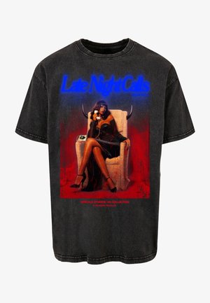 Czarny, oversize t-shirt zniszczonym nadrukiem przedstawiającym kobietę rozmawiającą przez telefon. Nadruk zawiera czerwone akcenty oraz niebieski tekst. Krótkie rękawy, bawełnowy materiał.