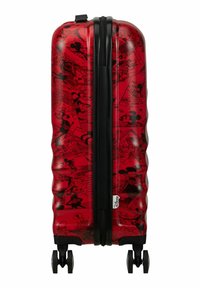 Valigia rigida rossa con superficie testurizzata. Presenta illustrazioni a fumetti di Topolino nere, manico retrattile e quattro ruote piroettanti.