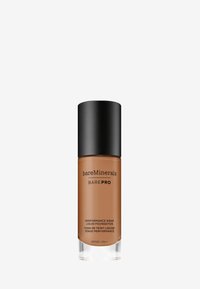 Base líquida BAREPRO de BareMinerals en un bote de vidrio marrón con tapa negra, marcada con un logo y una etiqueta SPF20 sobre un fondo blanco.