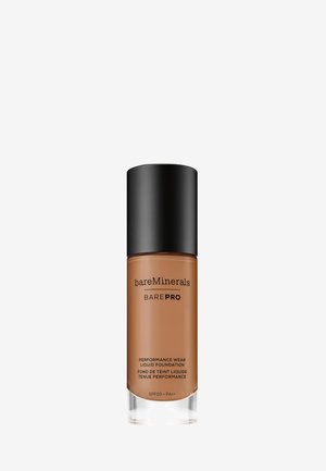 base líquida bareMinerals BAREPRO en un frasco de vidrio delgado con tapa negra, que presenta un líquido marrón medio y etiquetado con SPF 20.