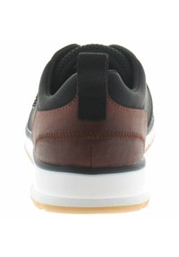 Black sneaker with brown leather accents, textured fabric at the heel, white midsole, and a rubber outsole for traction.