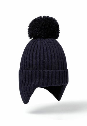 Bonnet tricoté bleu marine avec des côtes verticales, doté d'un grand pompon texturé sur le dessus et de rabats pour les oreilles pour plus de chaleur.