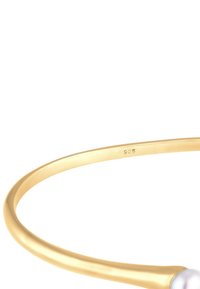 Guldpläterat armband med en slät, polerad yta, som har en vit pärla som accent och graverad "925" som indikerar silverinnehåll.