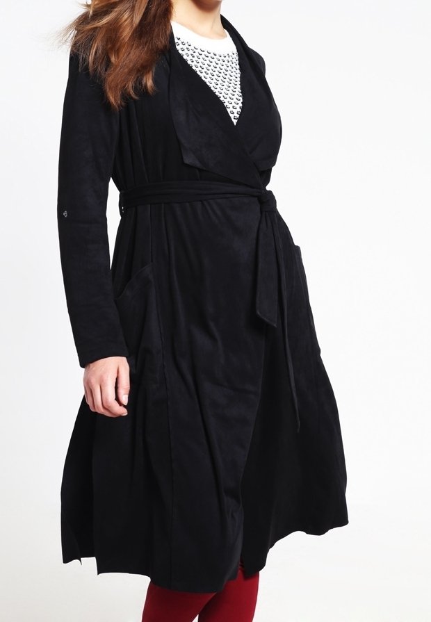 Svart mockasininspirerad omlottsrock med långa ärmar, ett knytbälte och två sidofickor. Rocken har en slät textur och framåtdrapering.