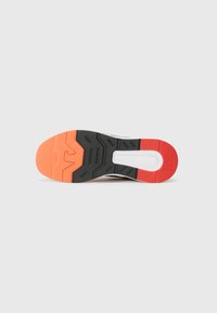 Shoe sole featuring a black rubber base, textured grooves, and an orange heel. White midsole with a rectangular cutout; brand logo embossed.