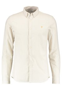 Hellbeiges Hemd aus Baumwolle mit Knopfleiste. Verfügt über einen klassischen Kragen, lange Ärmel, vordere Knopföffnung und ein kleines gelbes Logo auf der Brust.