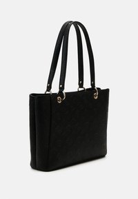 Musta olkalaukku, joka on valmistettu teksturoidusta materiaalista ja jossa on kohokuvioidut kuviot, kaksinkertaiset kahvat sekä kultaiset metalliosat. Suorakulmainen muoto.