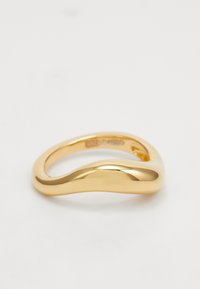 Anillo de oro con un diseño suave y ondulado. Acabado pulido con un interior redondeado, que muestra una forma fluida y sin costuras.
