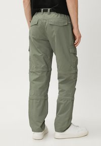 Olijfgroene cargo broek, gemaakt van lichtgewicht stof, met meerdere zakken, ritssluitingsecties en een relaxte pasvorm.