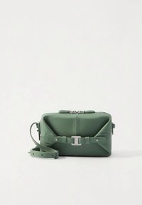 Green leather crossbody bag featuring a rectangular shape, zip closure, and decorative strap accents, with silver-tone hardware details.