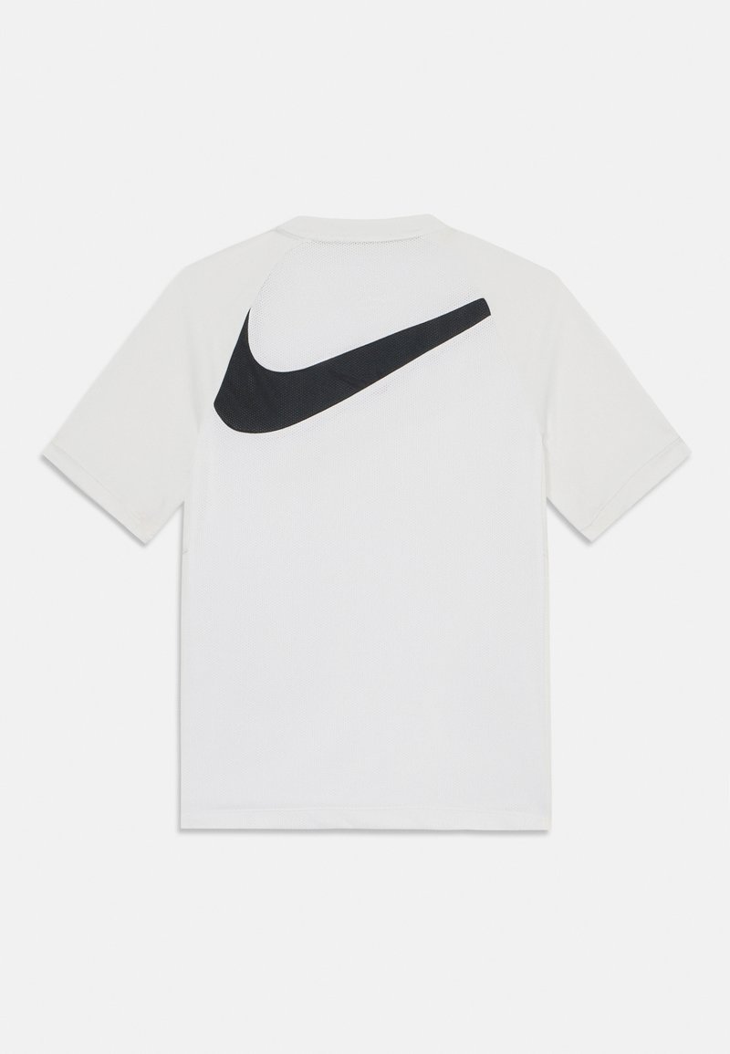 Biała koszulka z krótkim rękawem o siatkowej fakturze z dużym czarnym logo Nike z tyłu. Prosty krój z okrągłym dekoltem.