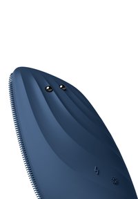 Mörkblå silikonvårdsredskap med en strömlinjeformad form, med texturerade räfflor på ena sidan och två svarta ögon på framsidan.