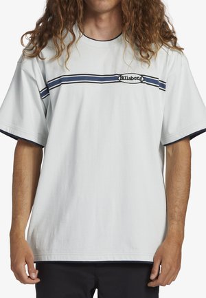 Lys grå bomulds t-shirt med korte ærmer, der har et marineblåt stribet design på brystet og et lille logo. Glat tekstur og afslappet pasform.