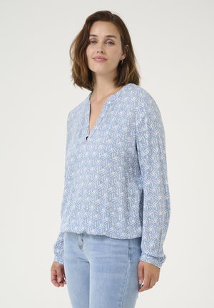 Light blue long-sleeve blouse with a V-neck, featuring a white abstract pattern, soft fabric, and gathered cuffs at the wrists.